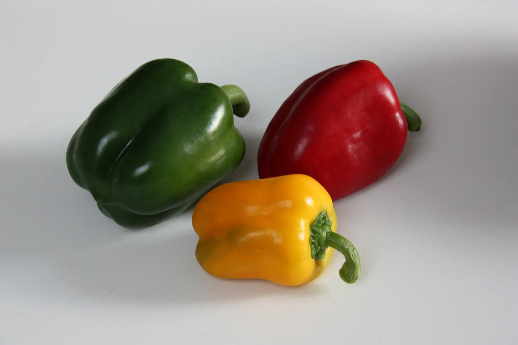 Glossy bell peppers ripening on the plant.